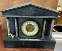 A black slate mantle clock of architectural form,