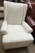 A cream upholstered wing back elbow chair