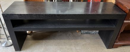 A black ash console table, with a rectangular top above a shelf on slab sides,