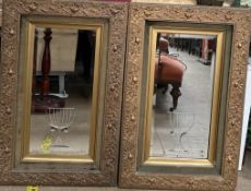 A pair of gilt framed wall mirrors with a floral moulded border,