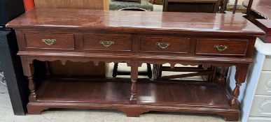A 20th century mahogany dresser base with a rectangular planked top above four drawers on ring