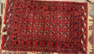 A red ground Turkoman rug with multiple guls to a red ground,