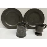 Two pewter plates together with a goblet and a spouted tankard