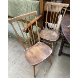 A pair of Ercol teak stick back dining chairs on tapering legs