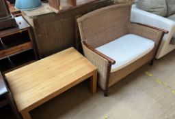 A caned two seater settee with a pad seat together with a coffee table