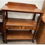 A Victorian mahogany buffet with a raised back and shelves with two drawers on casters,