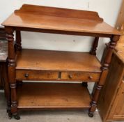 A Victorian mahogany buffet with a raised back and shelves with two drawers on casters,