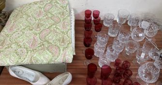 A bed spread together with cranberry glass and other drinking glasses etc