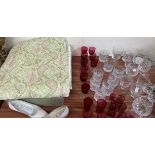 A bed spread together with cranberry glass and other drinking glasses etc