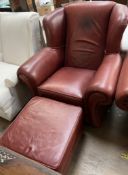 A brown leather upholstered wing back elbow chair with matching footstool