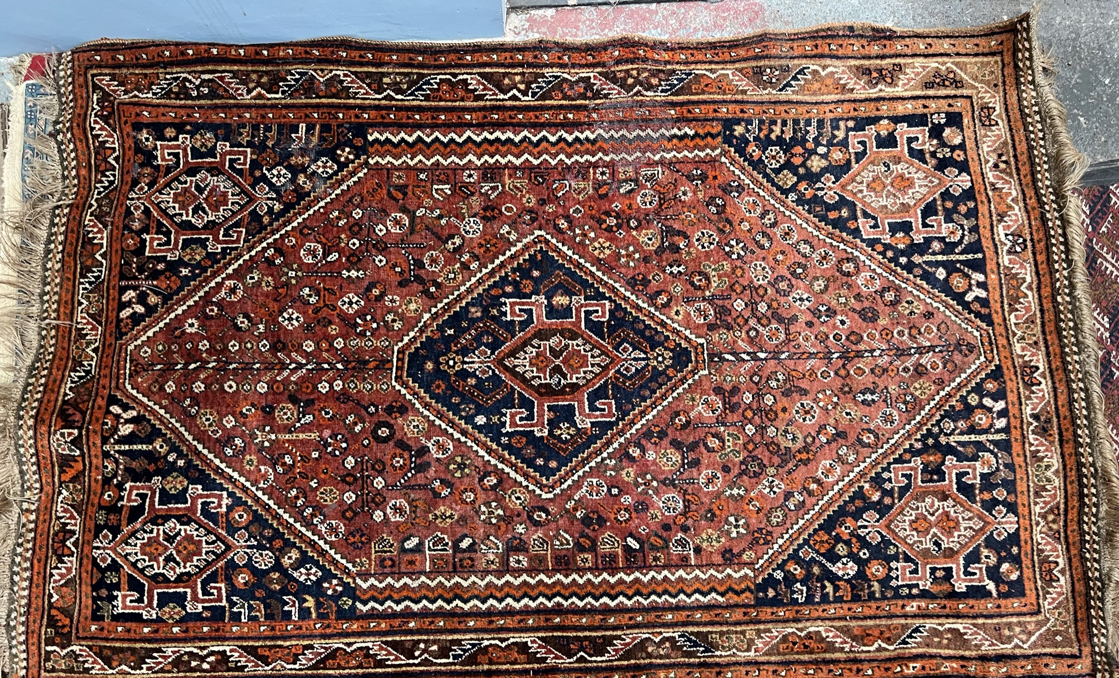 A red ground rug, with a central diamond shaped medallion,