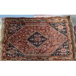A red ground rug, with a central diamond shaped medallion,
