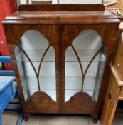 A 20th century walnut display cabinet with glazed doors and side on cabriole legs and pad feet