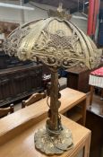 A brass table lamp with a lily pad decorated column