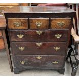 An 18th century oak chest with a rectangular planked top above an arrangement of six drawers on