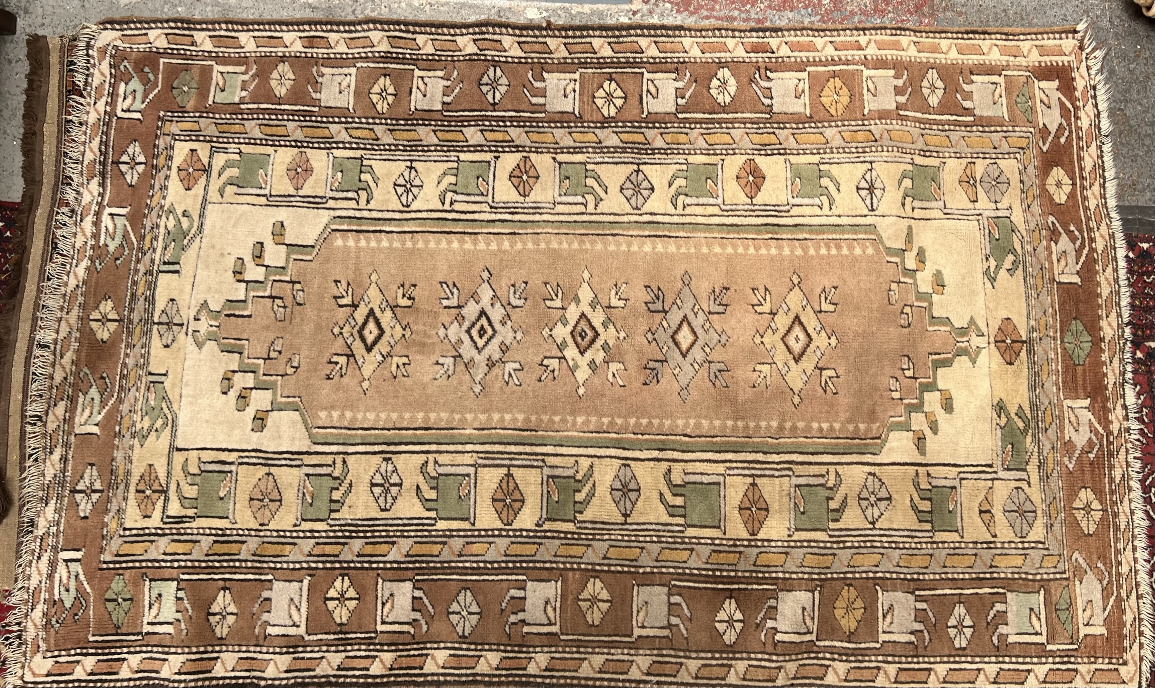 A rug with a cream ground, with central medallions and numerous guard stripes,