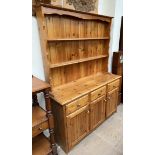 A 20th century pine dresser with a moulded cornice above two shelves,