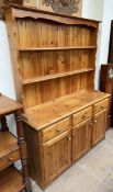 A 20th century pine dresser with a moulded cornice above two shelves,