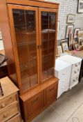 A modern teak bookcase / display cabinet together with two white and cream bedsides chests of