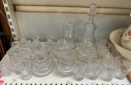 A bell shaped decanter together with a collection of crystal glasswares including candlesticks,