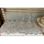 A bell shaped decanter together with a collection of crystal glasswares including candlesticks,