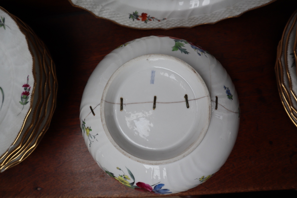 A 19th century Copenhagen porcelain part dinner set painted with garden flowers to a basket weave