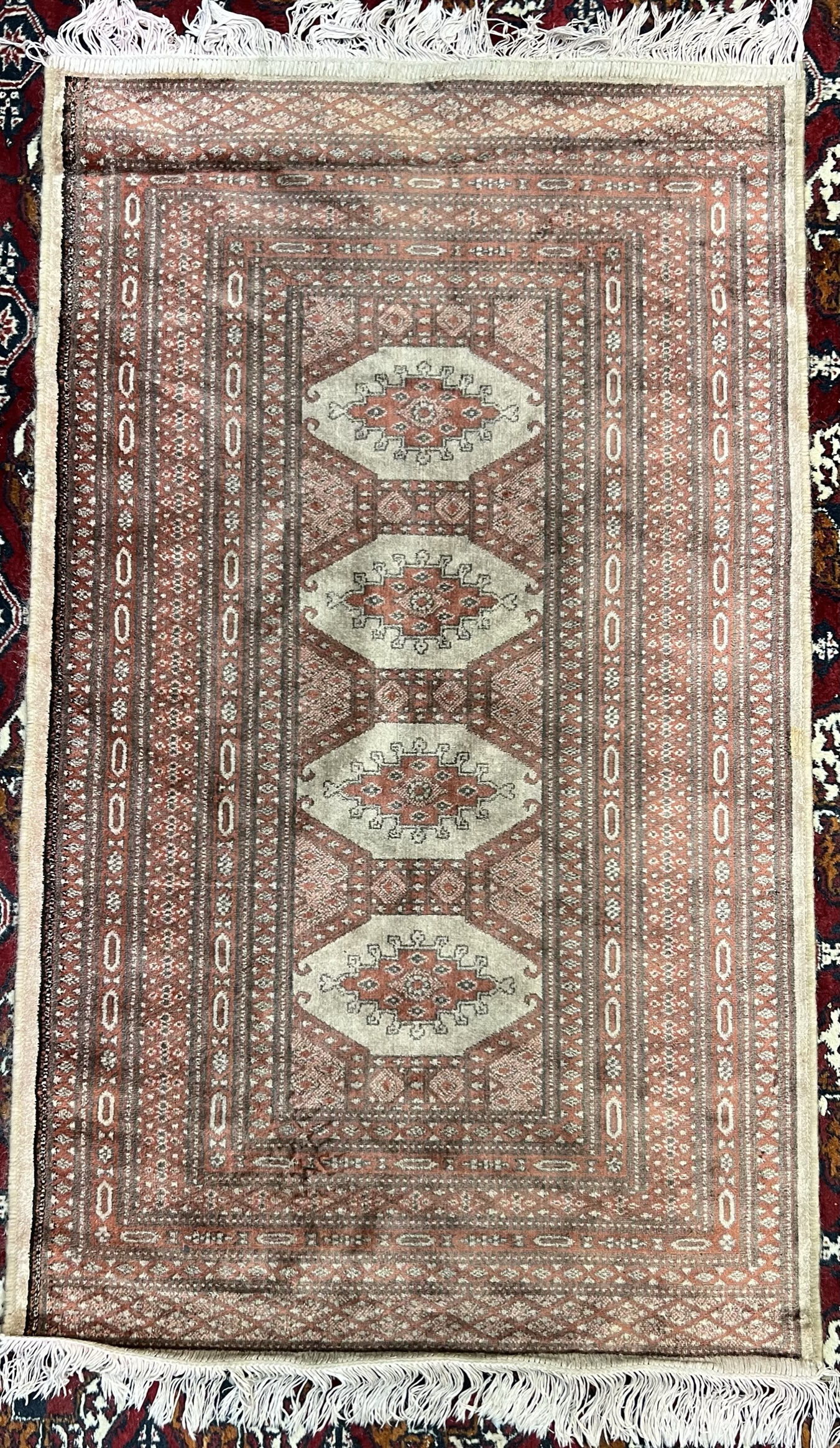A silk and wool blend rug / wall hanging with a red ground and four medallions and multiple guard