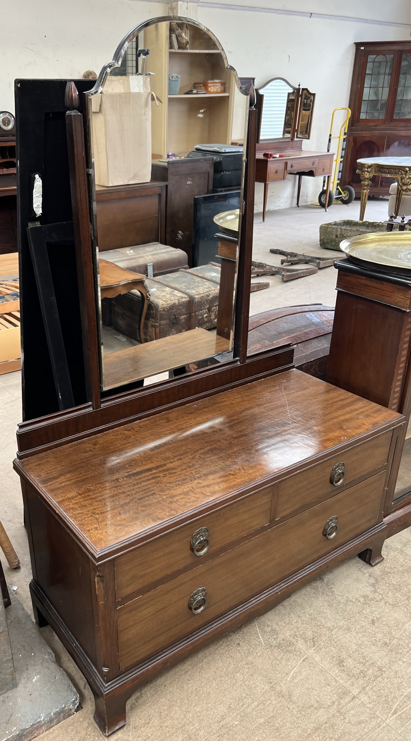 A mahogany dressing table with a shaped mirror above two short and one long drawer on bracket feet