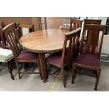 An oak dining table of circular form together with a set of five oak dining chairs