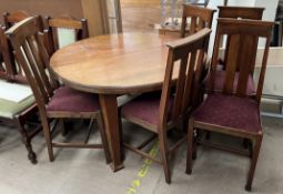 An oak dining table of circular form together with a set of five oak dining chairs