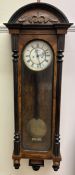 A Vienna regulator type wall clock, with a carved top and ebonised half columns,