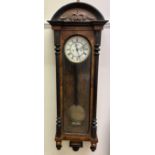 A Vienna regulator type wall clock, with a carved top and ebonised half columns,