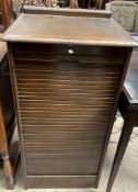 An Abbess oak cased filing cabinet with a tambour front enclosing nine drawers,