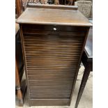 An Abbess oak cased filing cabinet with a tambour front enclosing nine drawers,