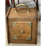An Edwardian oak coal scuttle with a hinged front,