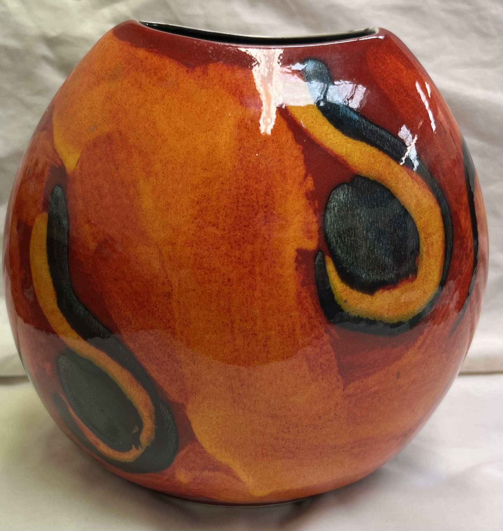 A Poole pottery vase of elliptical shape with an orange ground
