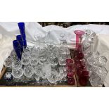 Cut glass decanters together with various drinking glasses, cranberry glass jugs,