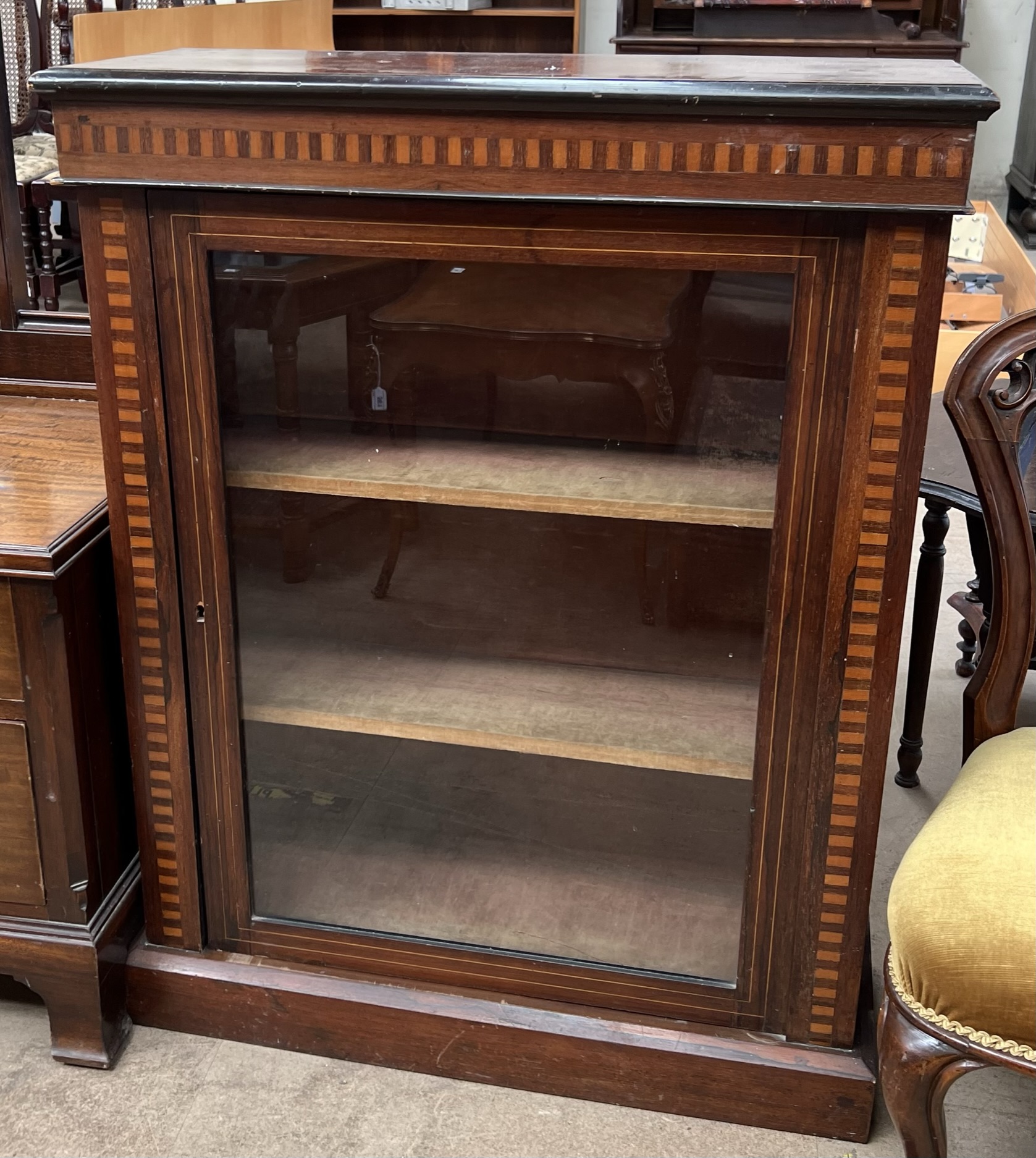 A Victorian rosewood bookcase with a rectangular top above a glazed door on a plinth base