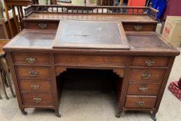 An Edwardian desk with a three quarter gallery, and sloping fall,