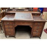 An Edwardian desk with a three quarter gallery, and sloping fall,