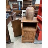 An oak pot cupboard with a linen fold front together with a mirror and a stoneware storage jar