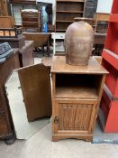 An oak pot cupboard with a linen fold front together with a mirror and a stoneware storage jar