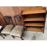 A pair of Edwardian carved salon chairs together with a bookcase