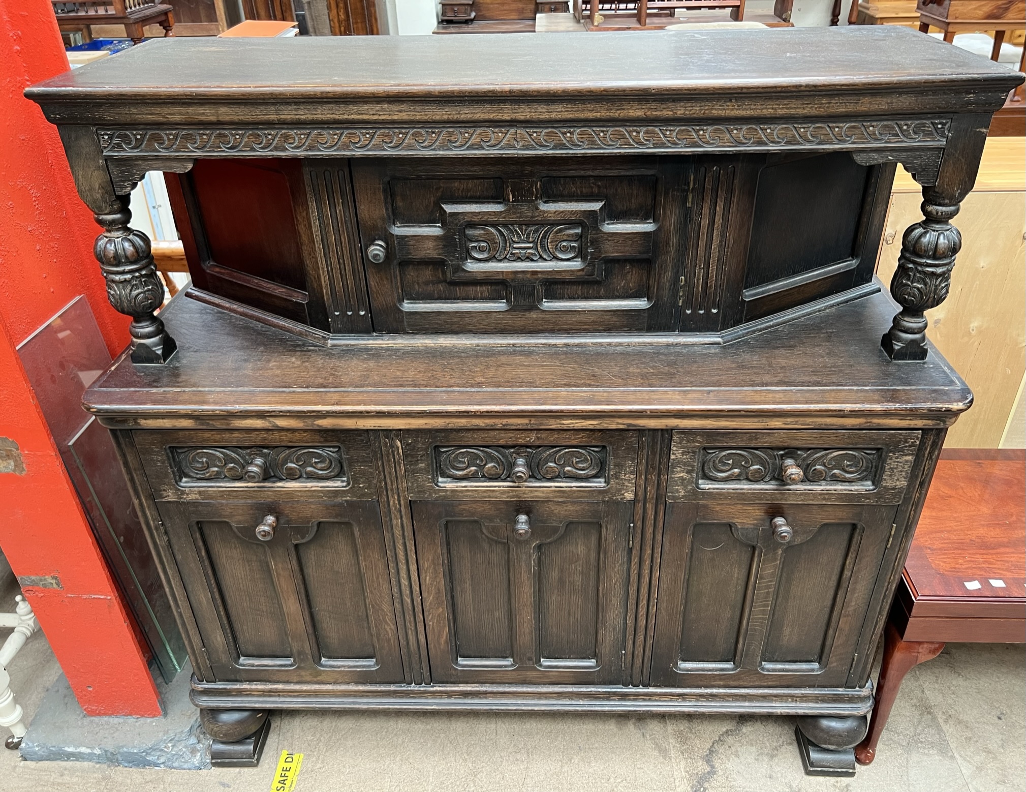 A 20th century oak court cupboard with a rectangular top above a central cupboard above three