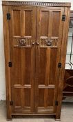 A 20th century oak hall robe, with carved panelled doors on stiles,
