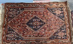 A red ground rug, with a central diamond shaped medallion,