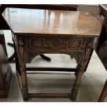 A 20th century oak side table with a carved frieze drawer on ring turned legs
