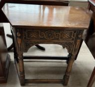 A 20th century oak side table with a carved frieze drawer on ring turned legs