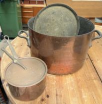 A large copper cooking pot together with a copper saucepan and lid and a brass tray