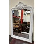 A white painted overmantle mirror with a carved cresting rail